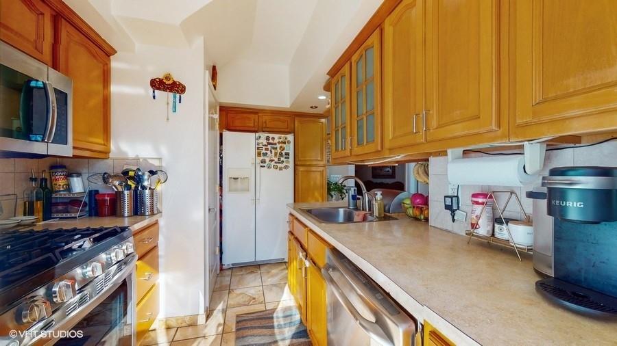 340 86th Street Brooklyn, NY 11209 - Photo 8 of 20 a kitchen with stainless steel appliances granite countertop a sink a stove and a refrigerator