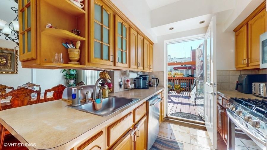 340 86th Street Brooklyn, NY 11209 - Photo 9 of 20 a kitchen with stainless steel appliances granite countertop a sink and cabinets