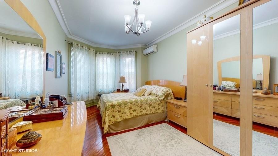 340 86th Street Brooklyn, NY 11209 - Photo 10 of 20 a bedroom with furniture and a chandelier