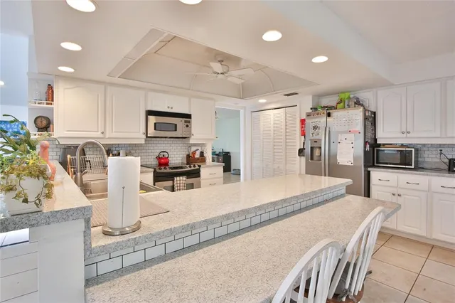 a kitchen with stainless steel appliances granite countertop a refrigerator a stove top oven a sink and dishwasher