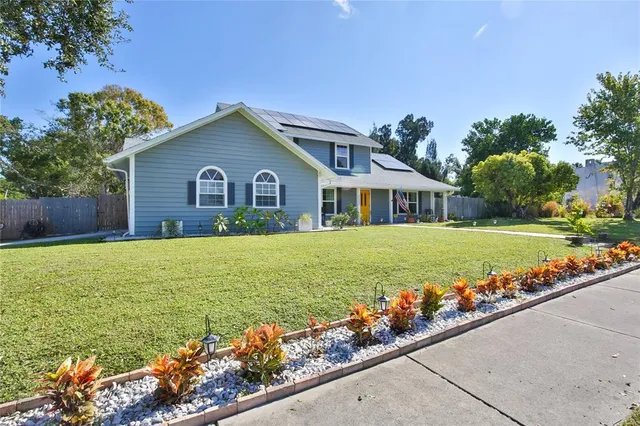 a view of house with a yard and potted plants