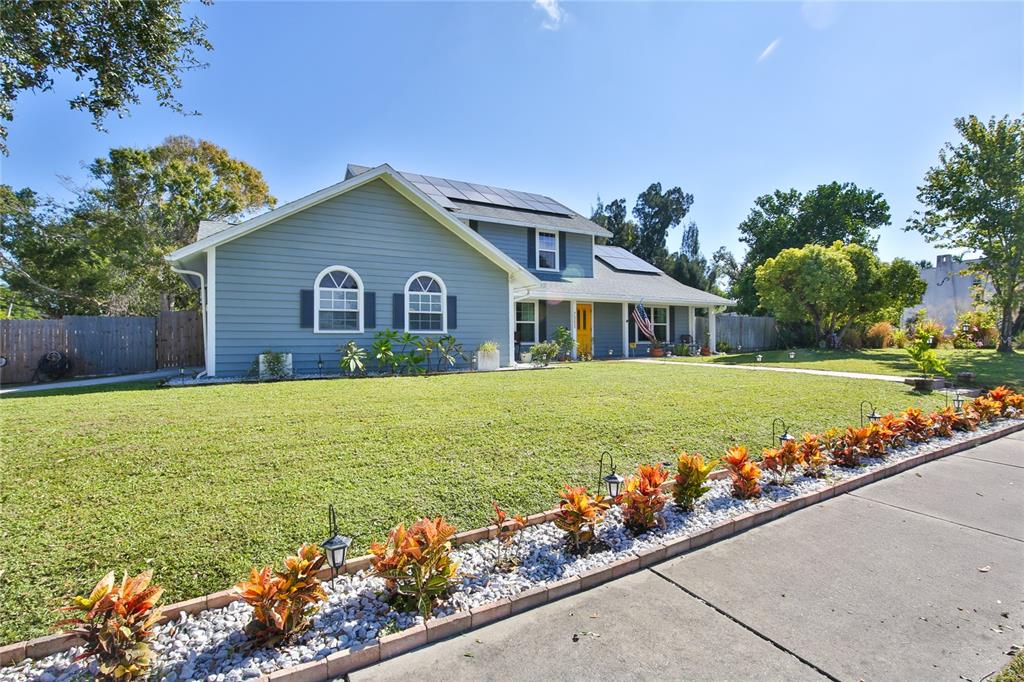 7303 Manatee Street Sarasota, FL 34243 - Photo 2 of 39 a view of house with a yard and potted plants