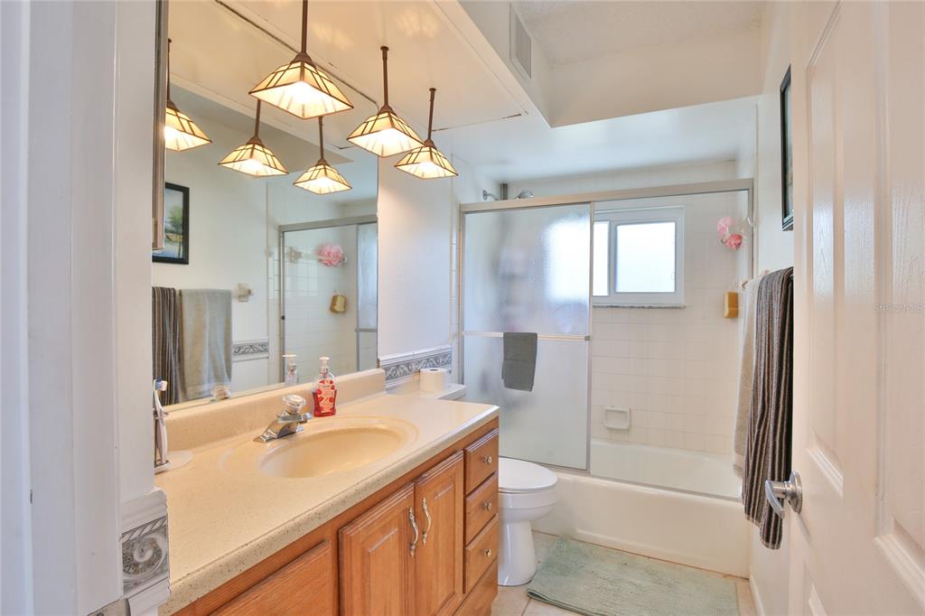 7303 Manatee Street Sarasota, FL 34243 - Photo 27 of 39 a bathroom with a sink a toilet a mirror and shower