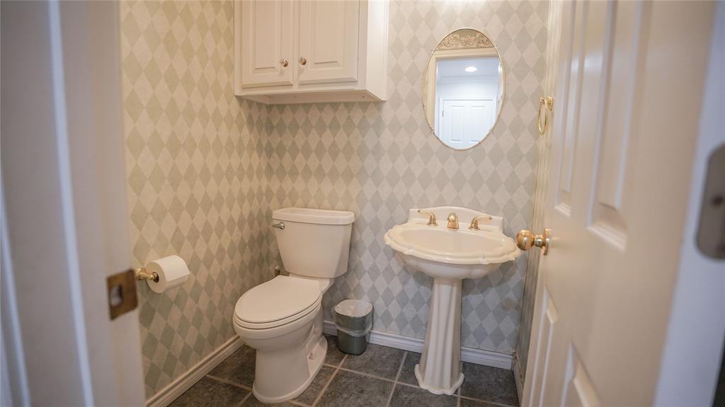 1041 Clarence Road Temple, TX 76501 - Photo 13 of 36 a white toilet sitting next to a bathroom sink