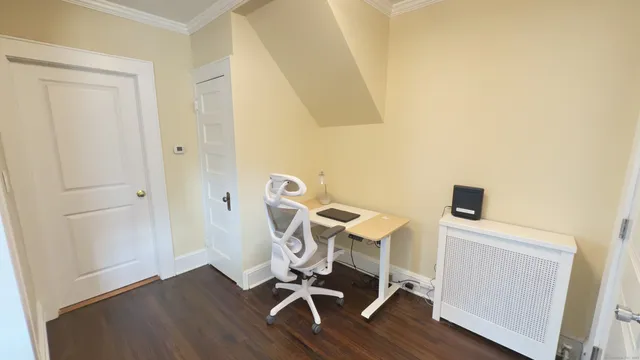 a view of a workspace with furniture and wooden floor
