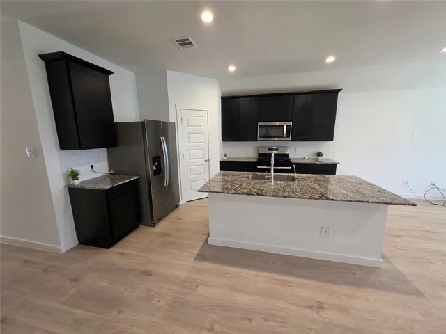 a kitchen with stainless steel appliances granite countertop a sink stove and refrigerator