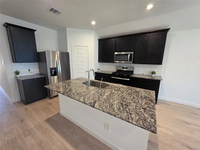 a view of kitchen with microwave and refrigerator