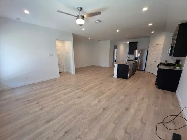 an empty room with a ceiling fan and a window
