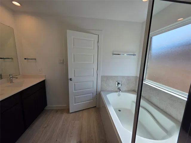 a view of a backyard with a tub and wooden fence