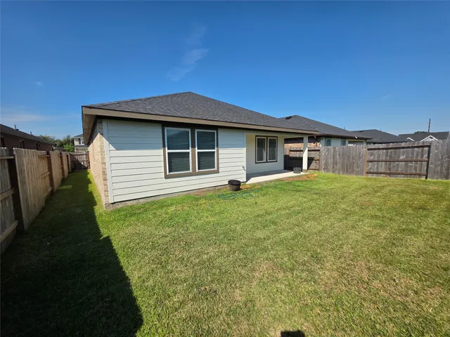 a view of a house with a yard and a large tree