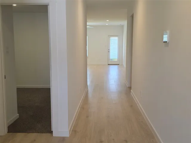 a view of a hallway with wooden floor