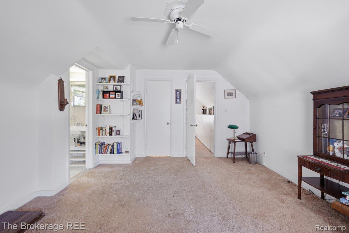 613 East Atherton Road Flint, MI 48507 - Photo 23 of 42 Sloped ceilings, built-in shelving, and a ceiling fan