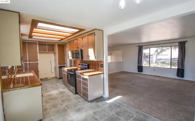 a kitchen with stainless steel appliances granite countertop a sink and a refrigerator