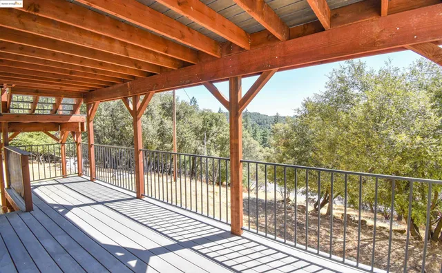 a view of a balcony with wooden floor and fence