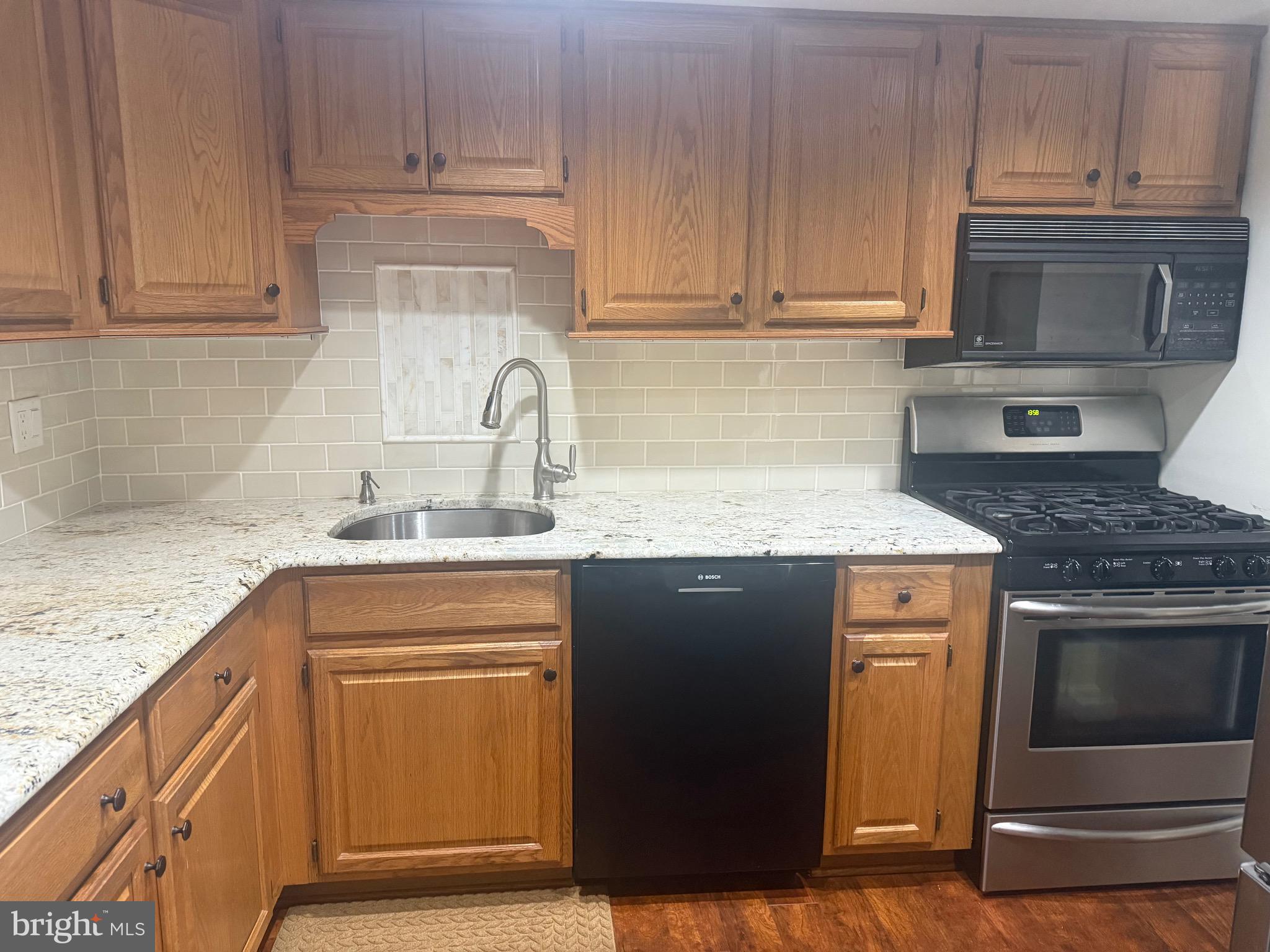 76 Old Forge Crossing, Unit 76 Devon, PA 19333 - Photo 8 of 17 a kitchen with granite countertop cabinets stainless steel appliances and sink
