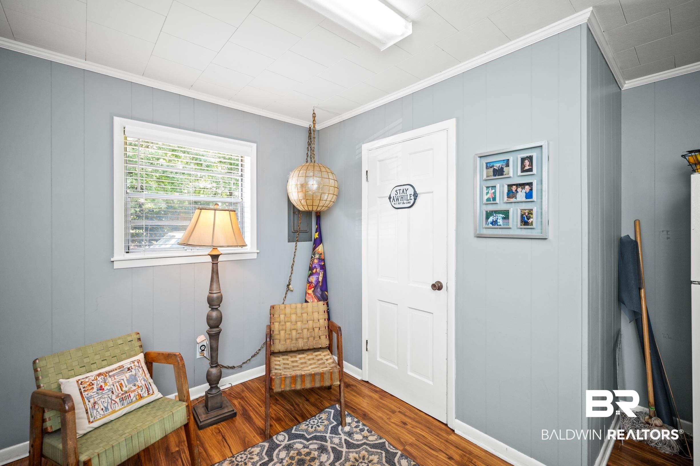 56 Old Bratt Road Atmore, AL 36502 - Photo 16 of 37 Living area with ornamental molding, wood finished floors, baseboards, and a decorative wall