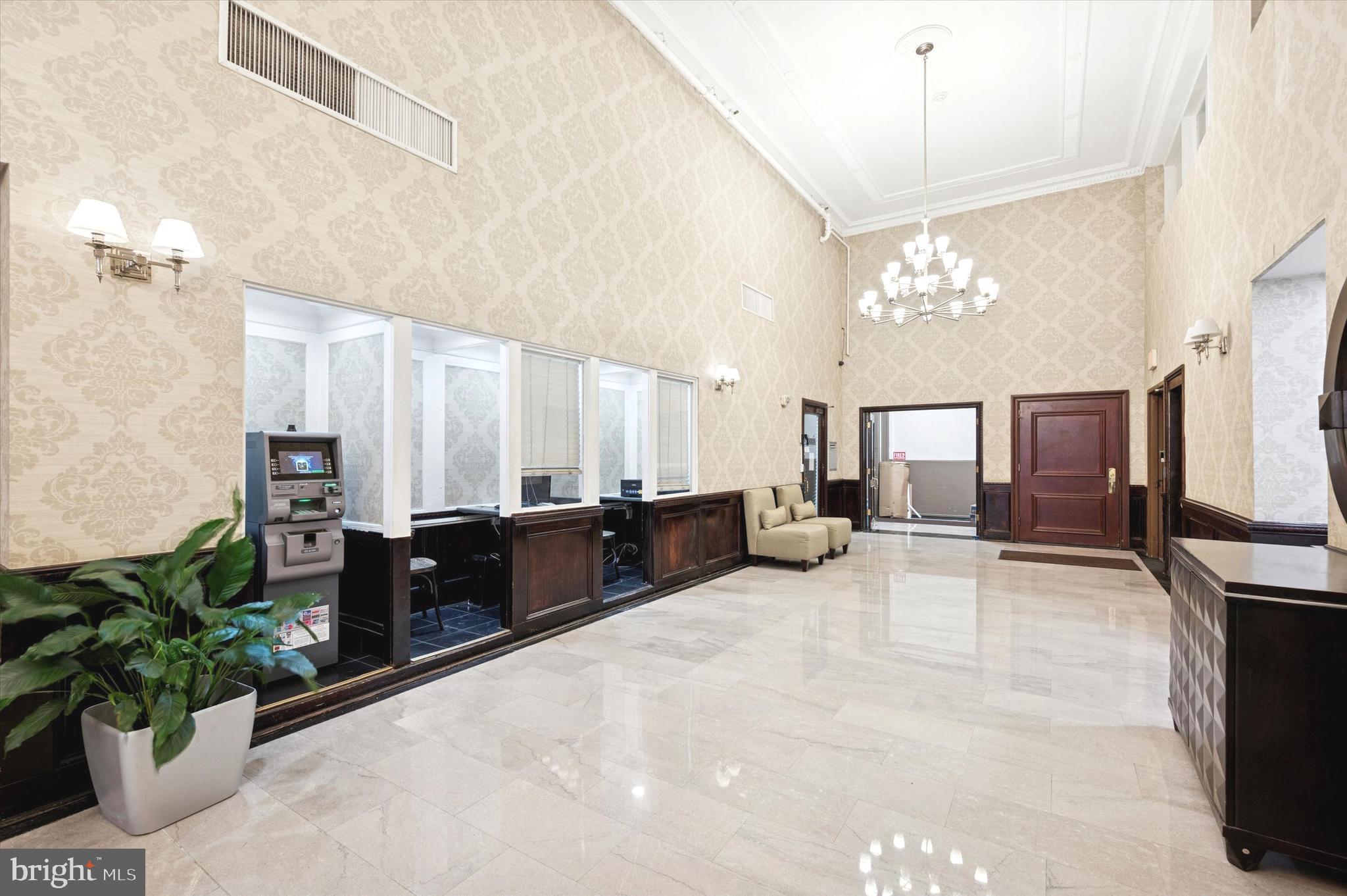 1324 Locust Street, Unit 1125 Philadelphia, PA 19107 - Photo 11 of 16 a large living room with furniture a chandelier and a flat screen tv