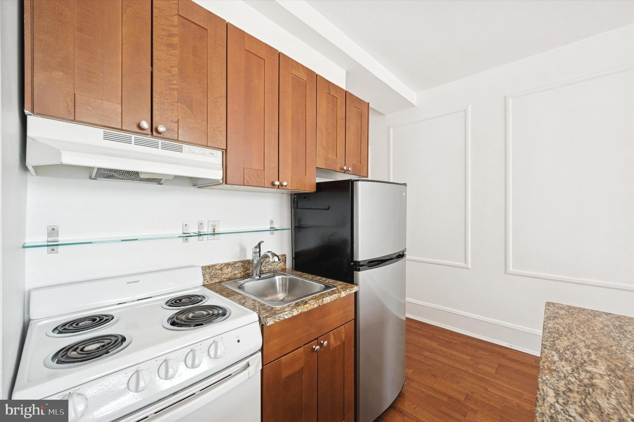 1324 Locust Street, Unit 1125 Philadelphia, PA 19107 - Photo 3 of 16 a kitchen with a stove and a refrigerator
