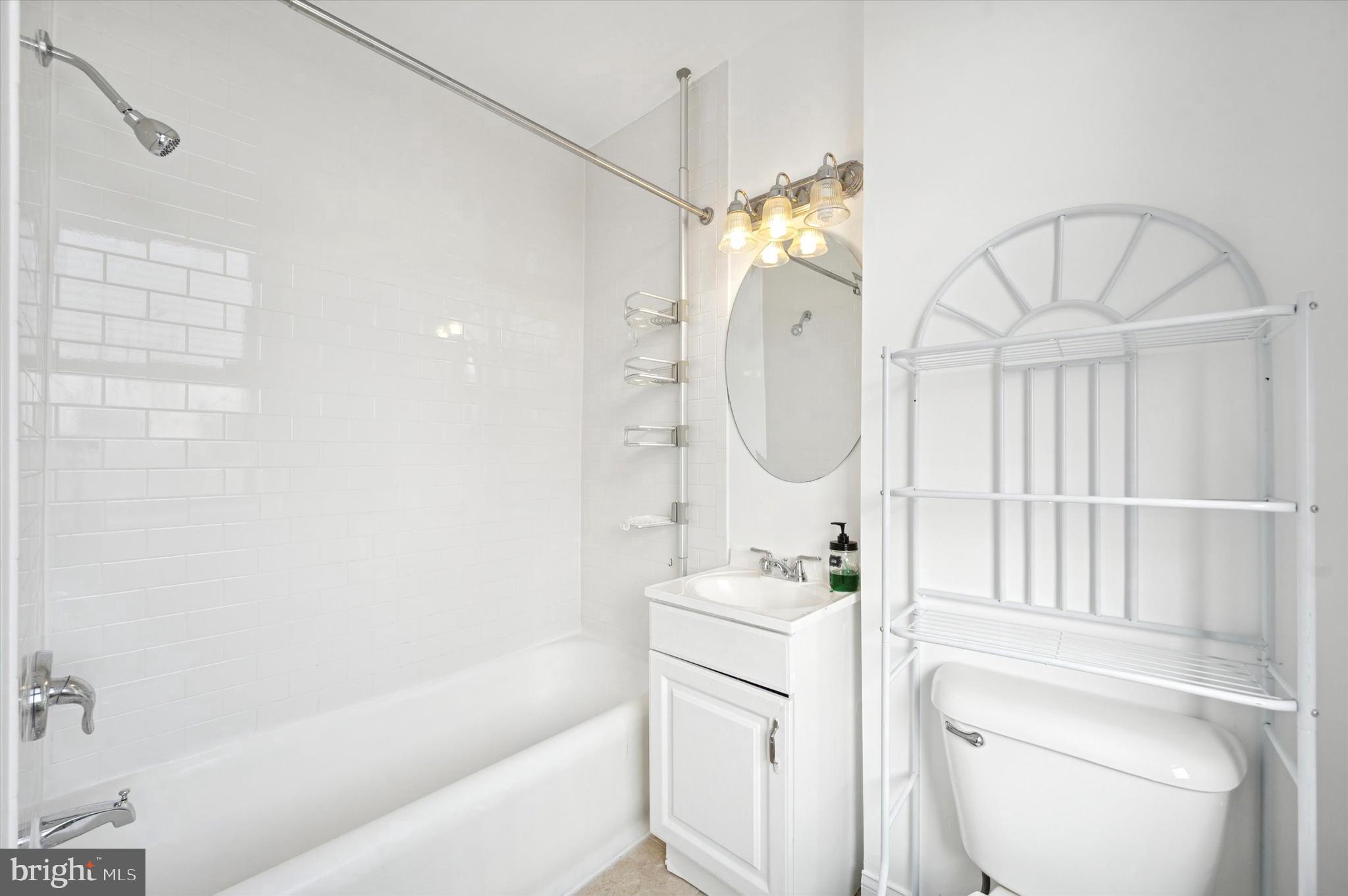 1324 Locust Street, Unit 1125 Philadelphia, PA 19107 - Photo 7 of 16 a bathroom with a sink a toilet and a mirror