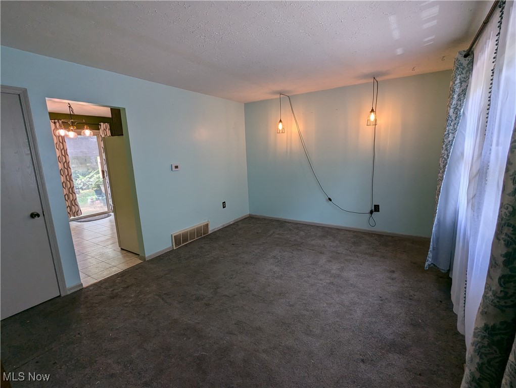 2500 Cleveland Road, Unit 202 Wooster, OH 44691 - Photo 11 of 22 Carpeted Living room featuring a chandelier and a textured ceiling