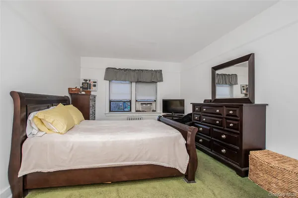 a bedroom with a bed and a flat tv screen on wall