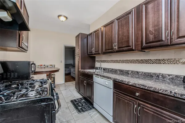 a kitchen with wooden cabinets a stove and a sink