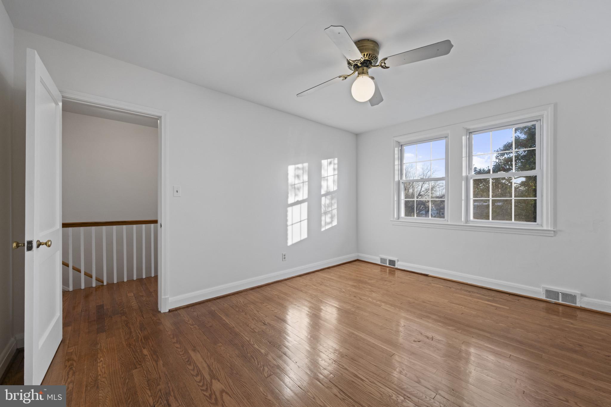 132 Overbrook Road Baltimore, MD 21212 - Photo 16 of 36 a view of an empty room with wooden floor and a window