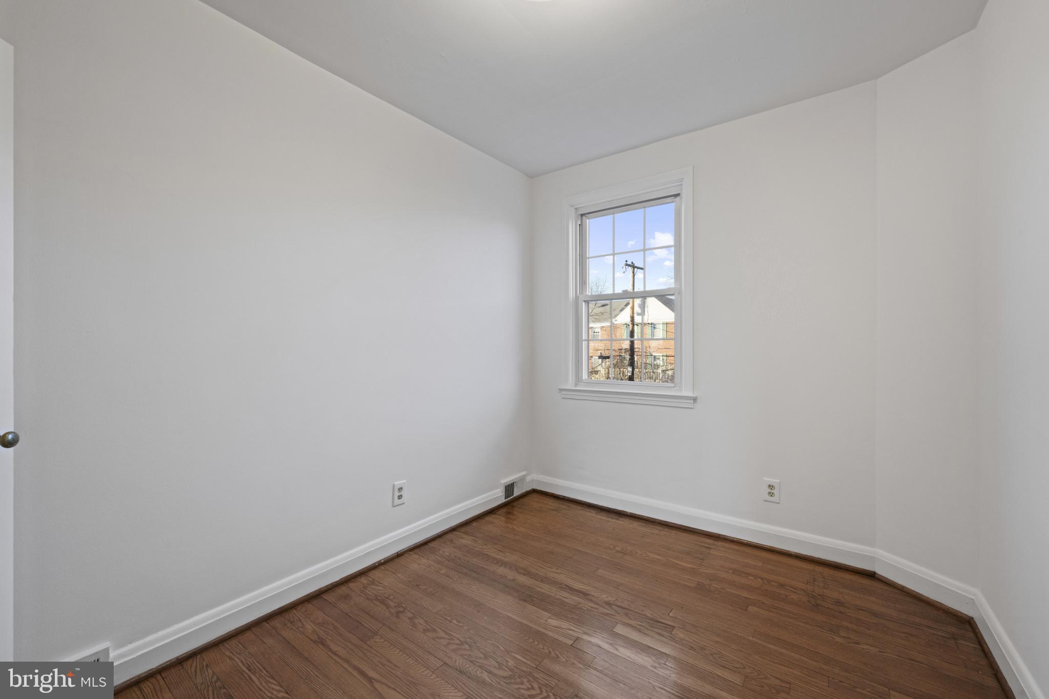 132 Overbrook Road Baltimore, MD 21212 - Photo 19 of 36 a view of an empty room with wooden floor and a window
