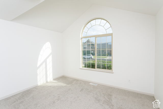 1742 Renaissance Way Springville, UT 84663 - Photo 11 of 23 Arched window with gridded panes, vaulted ceiling, neutral wall finish, and carpeted flooring