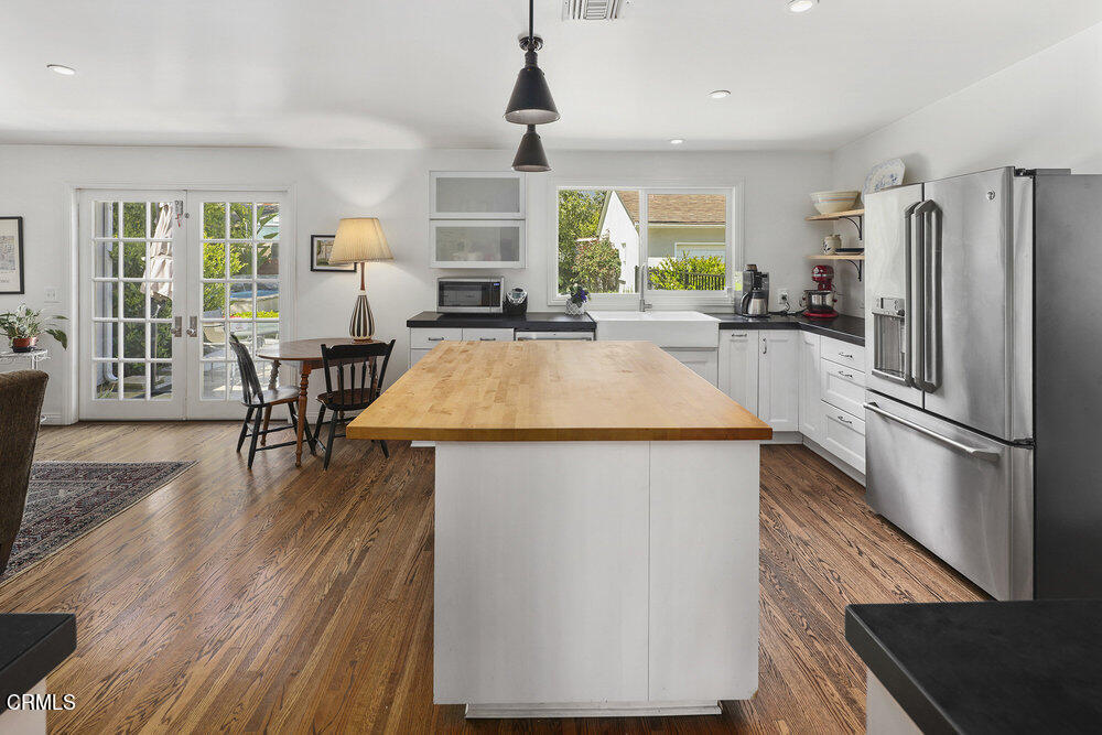 3657 Thorndale Road Pasadena, CA 91107 - Photo 14 of 44 a kitchen with stainless steel appliances a refrigerator a stove a dining table and chairs with wooden floor