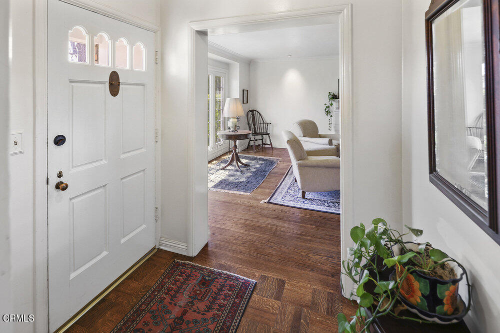 3657 Thorndale Road Pasadena, CA 91107 - Photo 3 of 44 a hallway with wooden floor and a chandelier