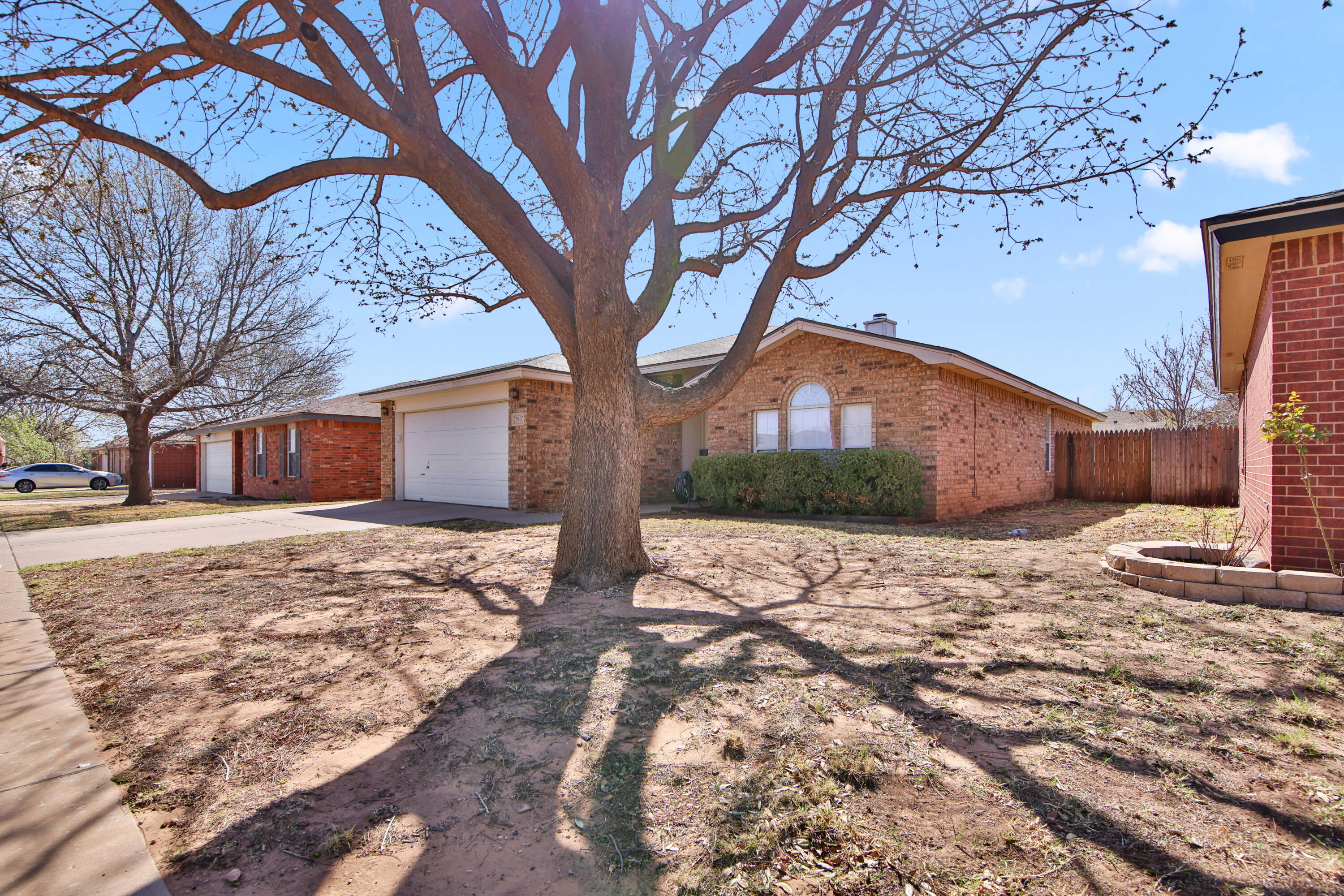 2907 90th Street Lubbock, TX 79423 - Photo 2 of 30 a street view with a large tree