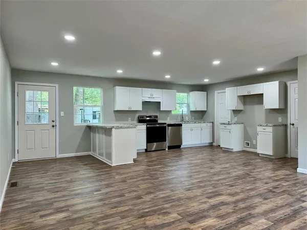 a kitchen with stainless steel appliances kitchen island granite countertop a stove and a refrigerator