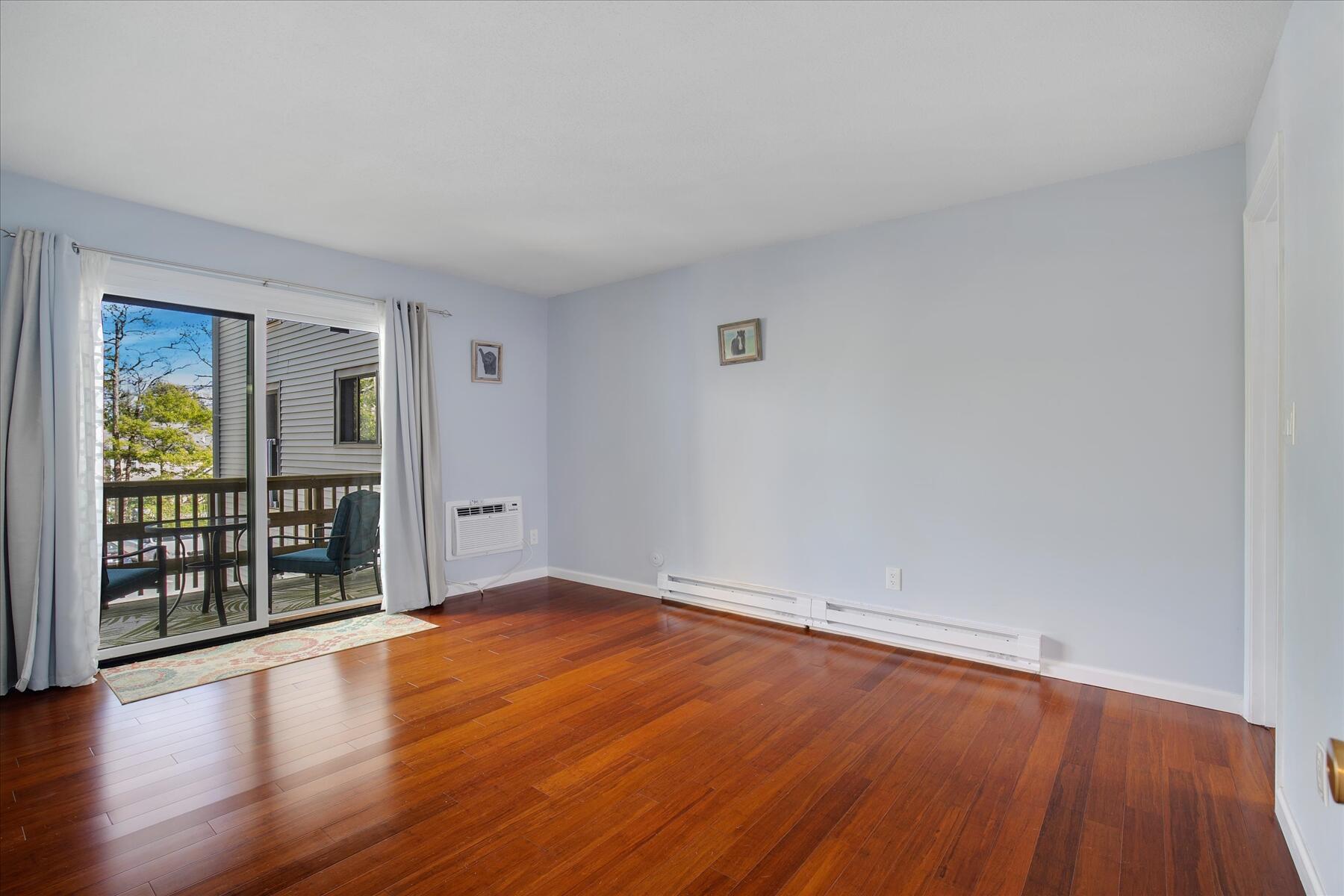 800 Bearses Way, Unit 1EB Hyannis, MA 02601 - Photo 20 of 37 a view of an empty room with wooden floor and a window