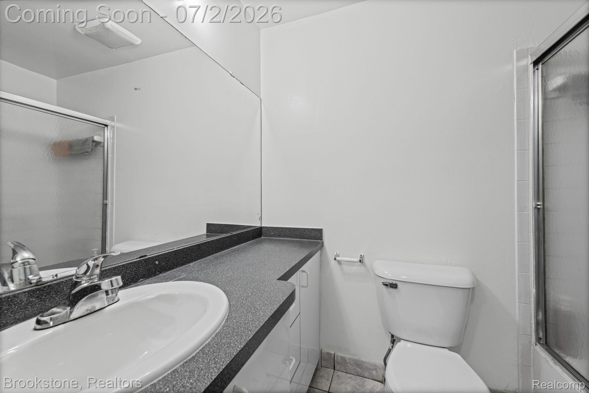 1925 Nicholas Court Warren, MI 48092 - Photo 18 of 26 Bathroom vanity with an integrated sink, polished chrome faucet, and expansive wall-mounted mirror