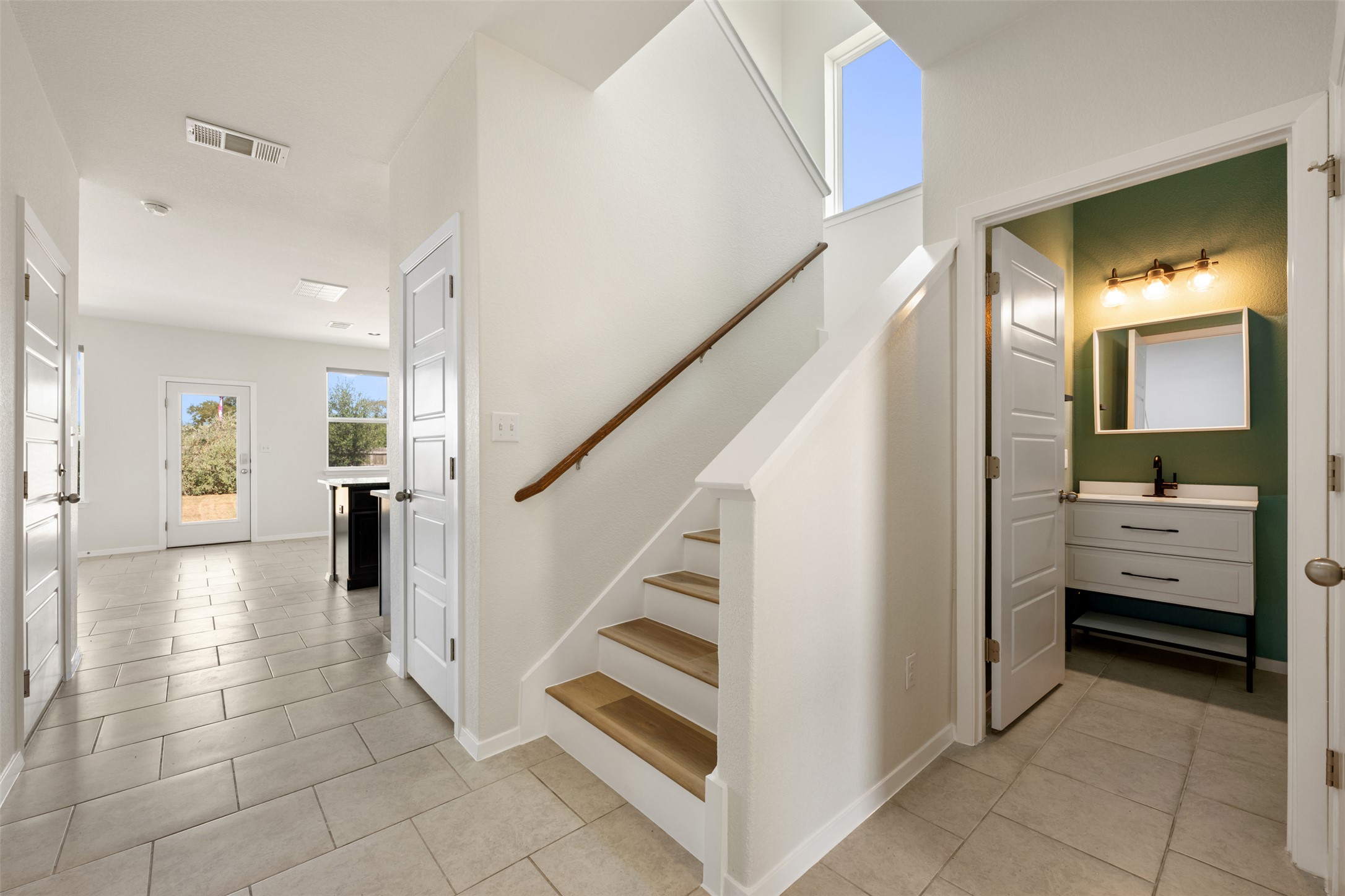 104 Cates Cove Elgin, TX 78621 - Photo 5 of 31 Tiled flooring and a modern wooden staircase.