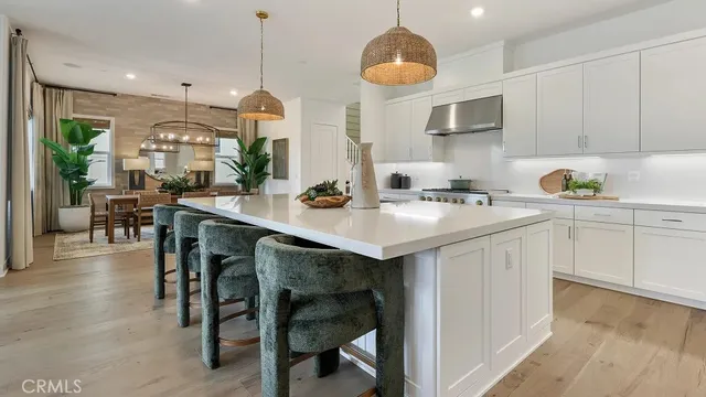 a kitchen with a sink a stove cabinets and wooden floor