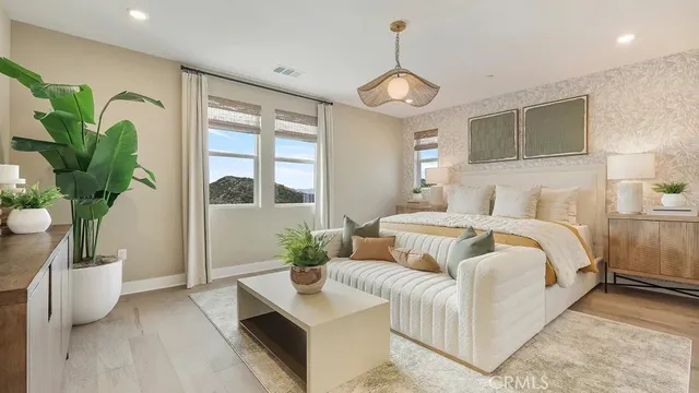 a bedroom with a large bed and a potted plant