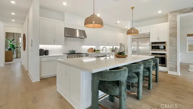 a kitchen with a sink a microwave a stove and chairs