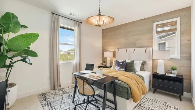 a bedroom with a bed a chandelier and a window