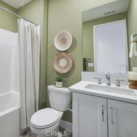 a bathroom with a toilet a sink a tub and mirror
