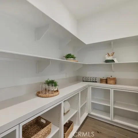 a kitchen with white cabinets and a wooden floor