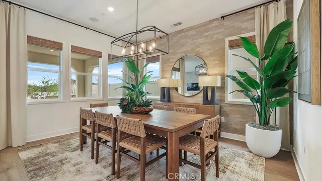 a dining room with furniture potted plants and wooden floor