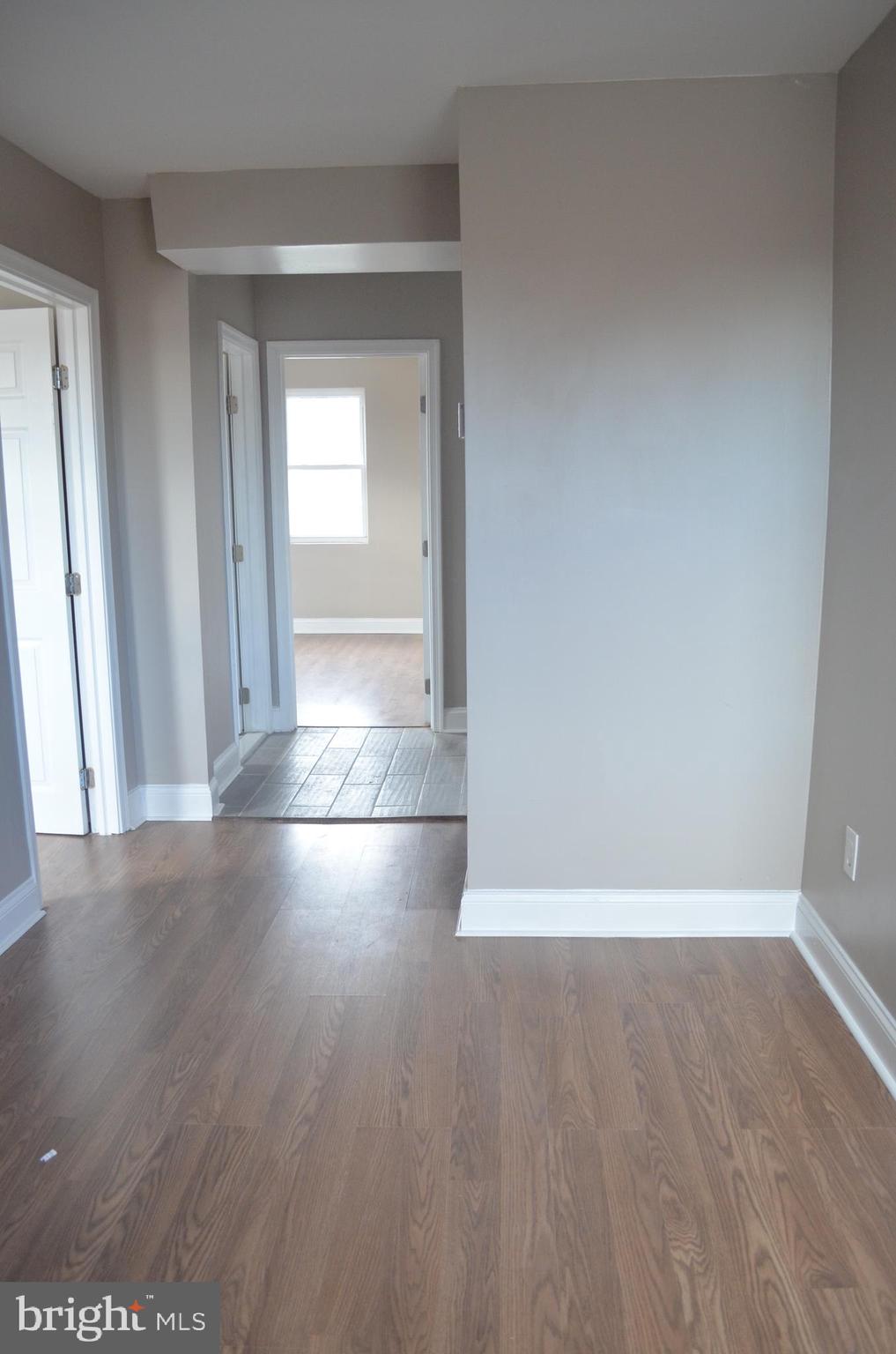 4952 Brookwood Road Baltimore, MD 21225 - Photo 13 of 13 an empty room with wooden floor and windows