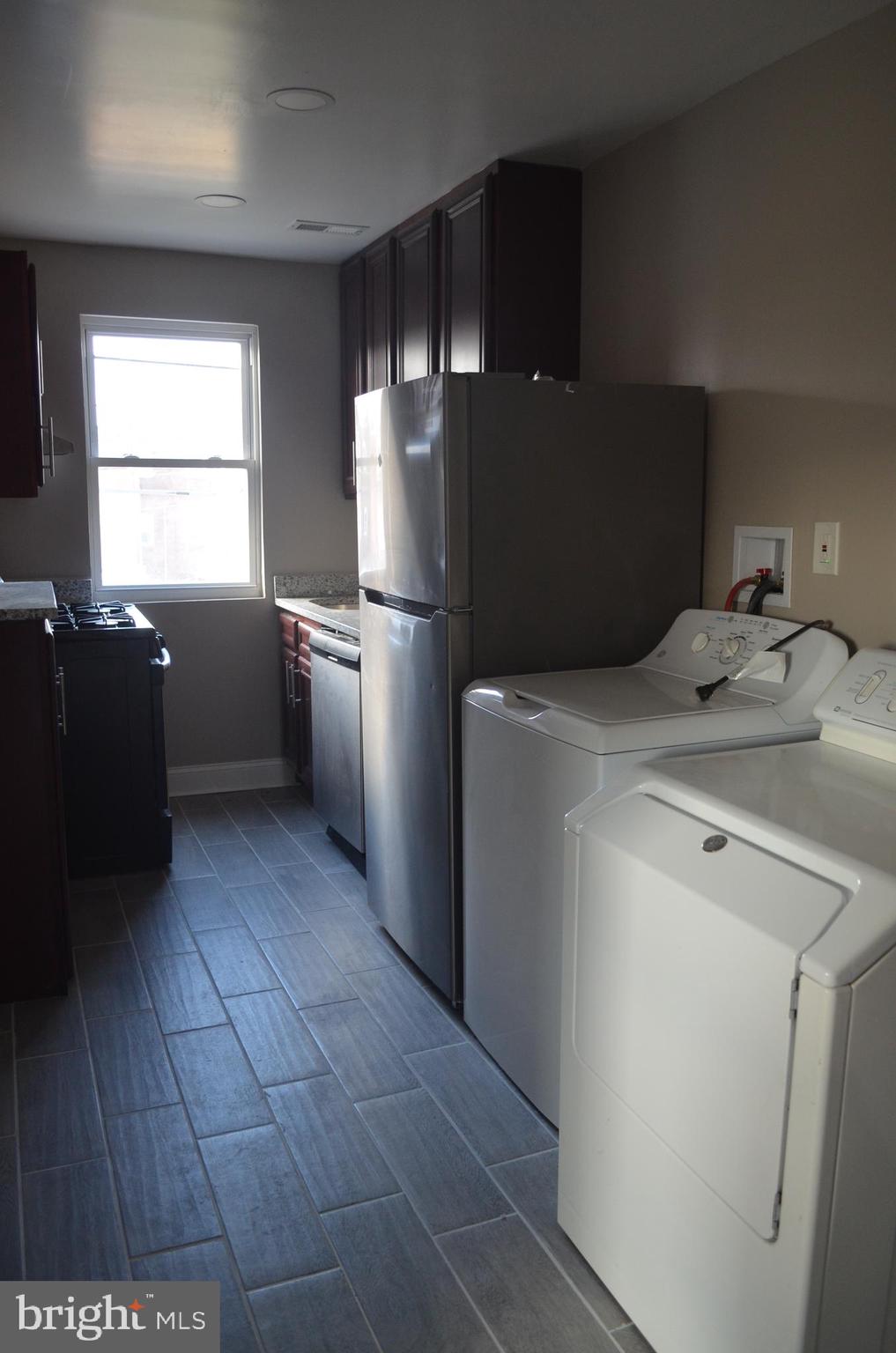 4952 Brookwood Road Baltimore, MD 21225 - Photo 2 of 13 a kitchen with a refrigerator and table