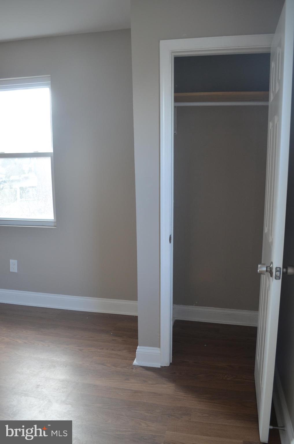4952 Brookwood Road Baltimore, MD 21225 - Photo 5 of 13 an empty room with wooden floor and a window