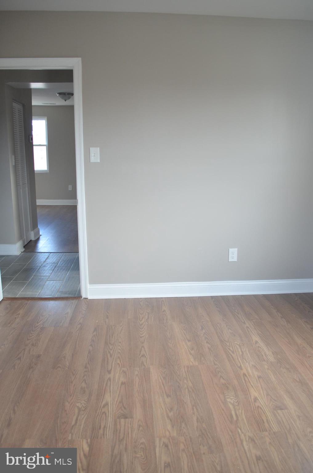 4952 Brookwood Road Baltimore, MD 21225 - Photo 7 of 13 a view of an empty room and wooden floor