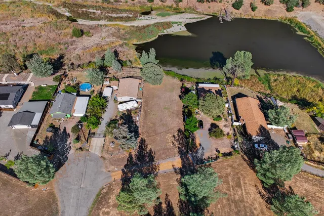 an aerial view of a house with a yard and lake view