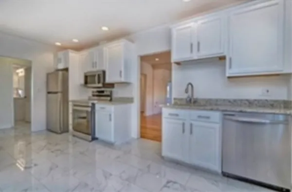 a kitchen with kitchen island granite countertop stainless steel appliances and sink