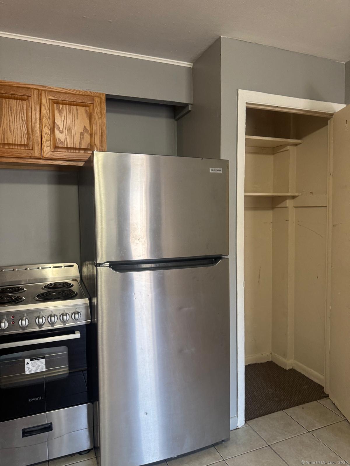 240 Oak Street, Unit 3 Bridgeport, CT 06604 - Photo 2 of 8 a white refrigerator freezer and a stove sitting inside of a kitchen